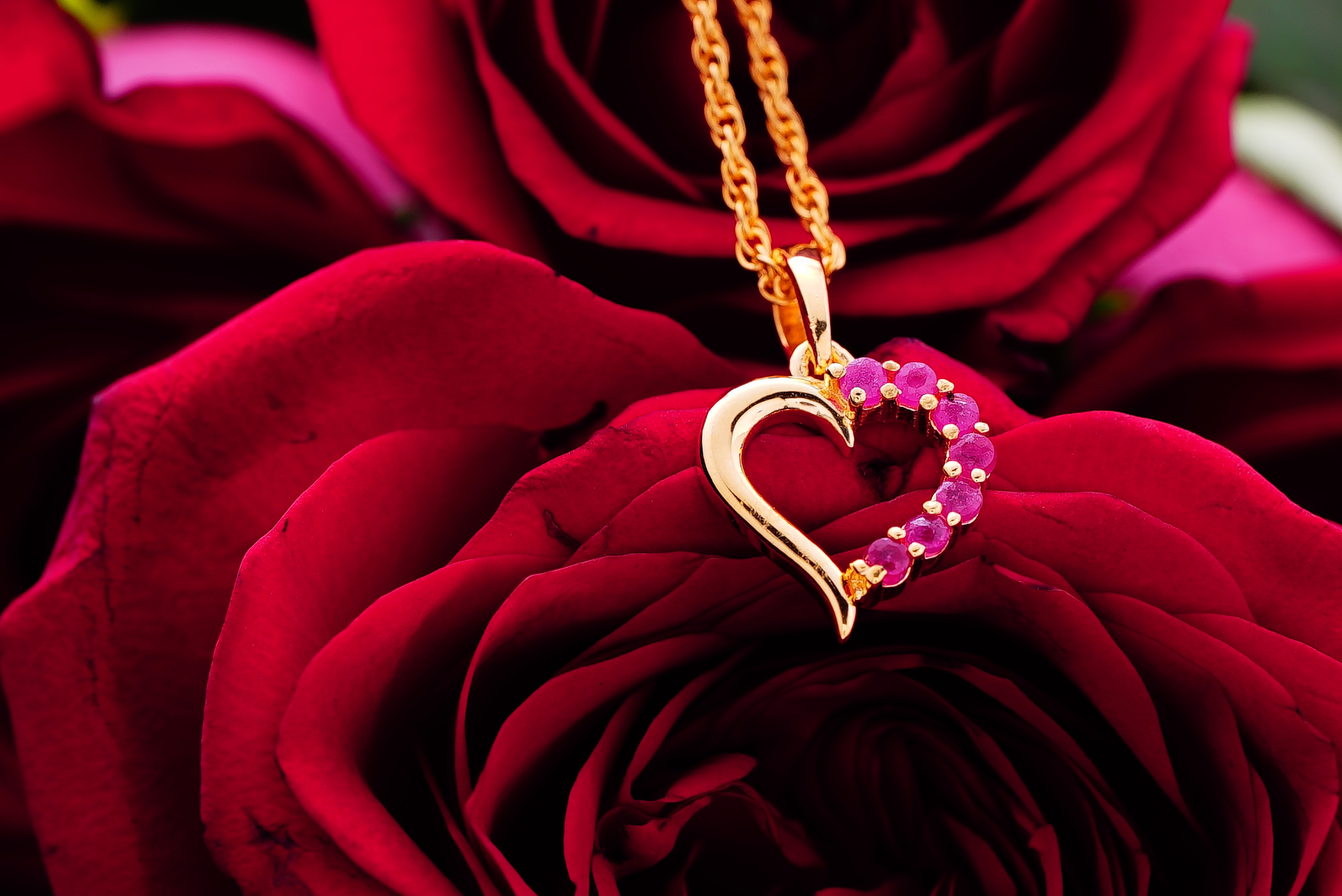 A gold heart-shaped pendant with rubies